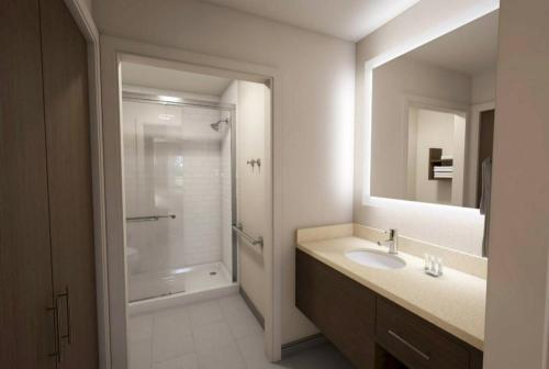 a bathroom with a sink and a shower and a mirror at Staybridge Suites - Lafayette, an IHG Hotel in Lafayette