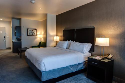 a hotel room with a large bed with white sheets at Holiday Inn Express & Suites Gatesville - N. Ft Hood by IHG in Gatesville