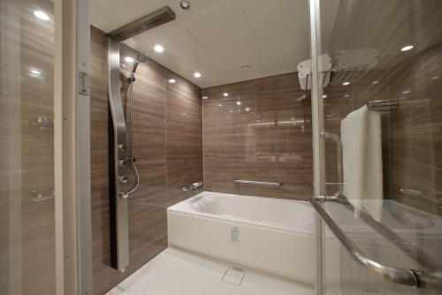 a bathroom with a bath tub and a shower at ANA Crowne Plaza Kumamoto New Sky by IHG in Kumamoto