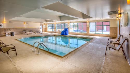 a large swimming pool in a building with chairs at Holiday Inn Express Wichita South by IHG in Wichita