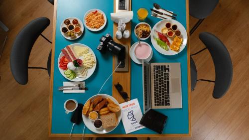 a table with plates of food and a laptop on it at Holiday Inn Express - Istanbul - Atakoy Metro by IHG in Istanbul