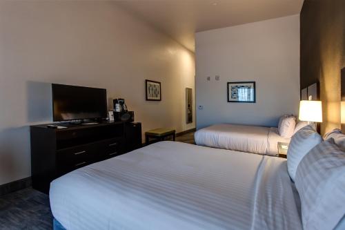 a hotel room with two beds and a flat screen tv at Holiday Inn Express & Suites Gatesville - N. Ft Hood by IHG in Gatesville
