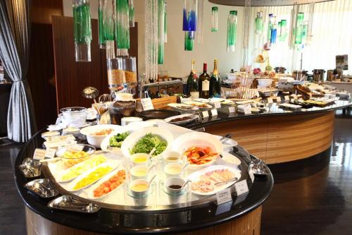 a buffet line with plates of food and bottles of wine at ANA Crowne Plaza Kumamoto New Sky by IHG in Kumamoto
