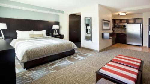um quarto de hotel com uma cama e um frigorífico em Staybridge Suites - Johnson City, an IHG Hotel em Johnson City