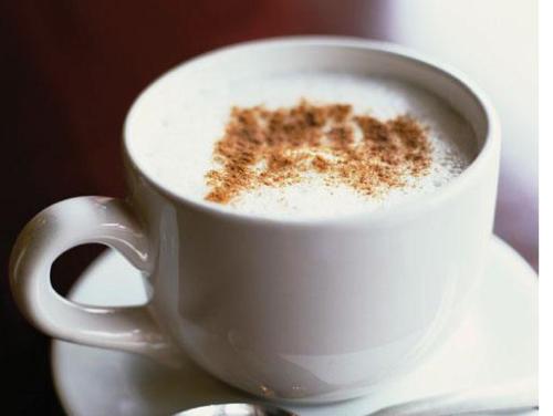 a white cup of coffee sitting on a table at Holiday Inn Express Manchester City Centre Arena by IHG in Manchester
