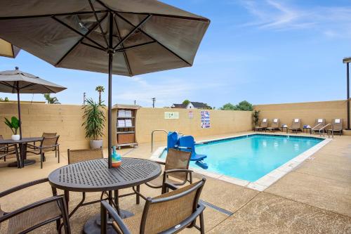 a patio with a table and chairs and a pool at Holiday Inn Express Costa Mesa, an IHG Hotel in Costa Mesa