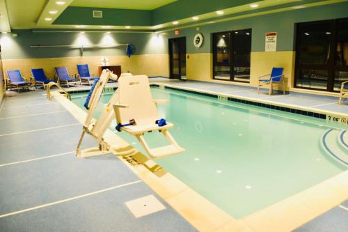 une piscine intérieure avec des chaises et une piscine dans l'établissement Holiday Inn Express & Suites - Middletown, an IHG Hotel, à Middletown