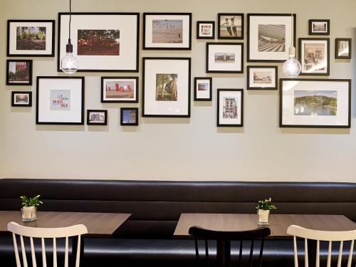 a dining room with two tables and pictures on the wall at Holiday Inn Express Hasselt by IHG in Hasselt