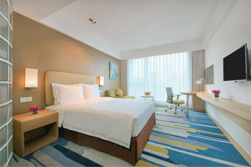 a hotel room with a large bed and a desk at Holiday Inn Express Hangzhou Gongshu by IHG in Hangzhou