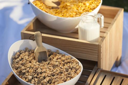a wooden tray with two bowls of food and a container of milk at Holiday Inn Express - Ringsheim by IHG in Ringsheim