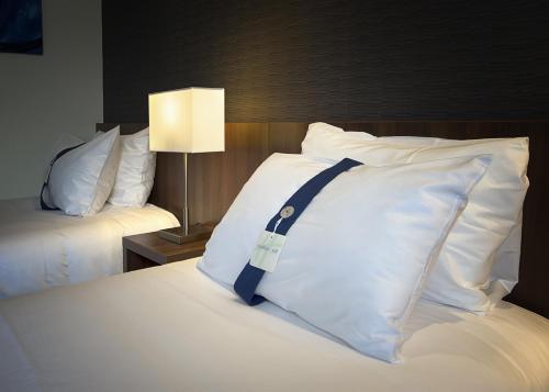 a pillow with a blue strap sits on a bed at Holiday Inn Express Lille Centre by IHG in Lille