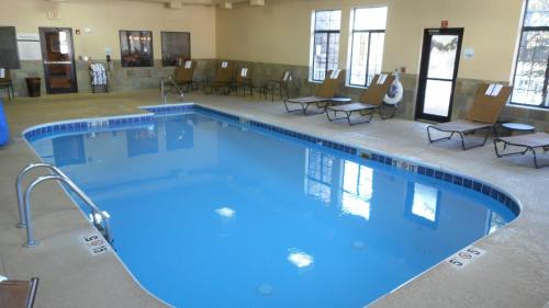 a large swimming pool in a room with tables and chairs at Holiday Inn Express Hocking Hills-Logan, an IHG Hotel in Logan