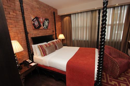 a bedroom with a bed and a brick wall at Hotel Indigo London Tower Hill by IHG in London