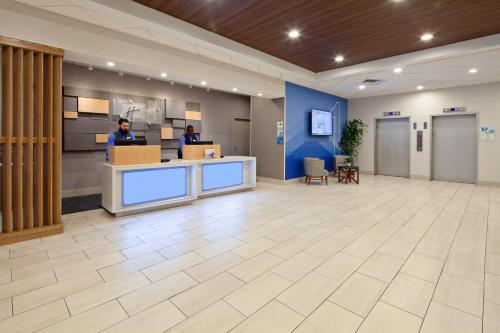 an office lobby with two people standing at a counter at Holiday Inn Express Los Angeles LAX Airport by IHG in Los Angeles