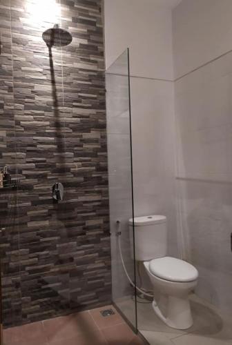 a bathroom with a toilet and a glass shower at BatanTop Ubud guest house in Ubud