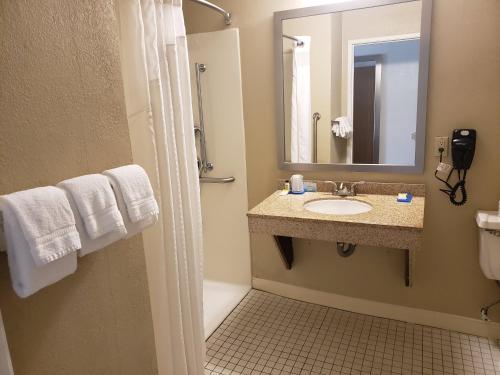 Holiday Inn Express Hotel Pittsburgh-North/Harmarville, an IHG Hotel في Harmarville: حمام مع حوض ومرآة