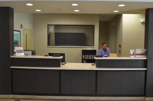 a man standing at a counter in a library at Candlewood Suites Harlingen by IHG in Harlingen