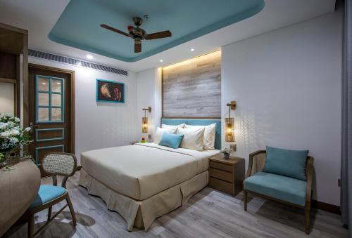 a bedroom with a bed and a blue chair at Icon Saigon - LifeStyle Design Hotel in Ho Chi Minh City