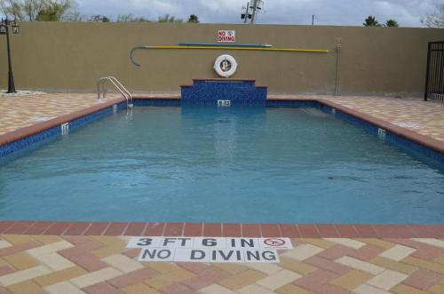 a swimming pool with a no diving sign in the water at Candlewood Suites Harlingen, an IHG Hotel in Harlingen