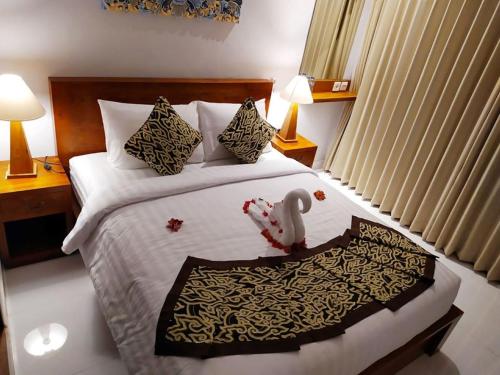 a hotel room with a bed with a swan on it at BatanTop Ubud guest house in Ubud