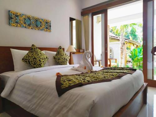 um quarto com uma cama grande e um bicho de peluche. em BatanTop Ubud guest house em Ubud