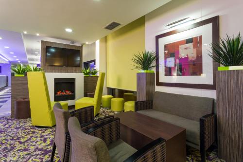 a lobby with a table and chairs and a fireplace at Holiday Inn Express Harlow, an IHG Hotel in Harlow