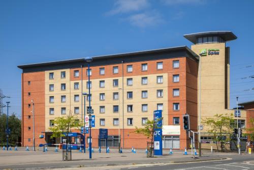 a large brick building on the corner of a street at Holiday Inn Express Leicester City by IHG in Leicester