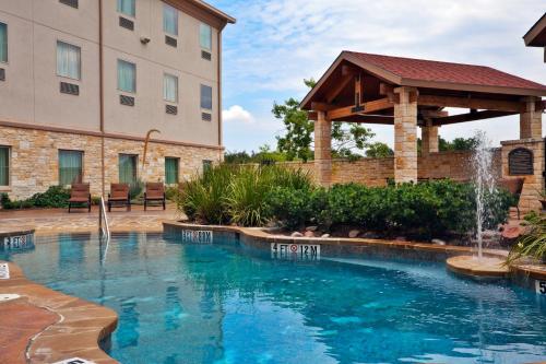 a swimming pool with a fountain in front of a building at Holiday Inn Express of Salado-Belton by IHG in Salado