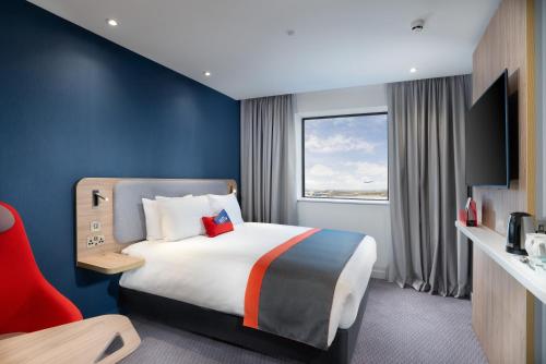 a hotel room with a large bed and a window at Holiday Inn Express - London Heathrow T4 by IHG in Hillingdon