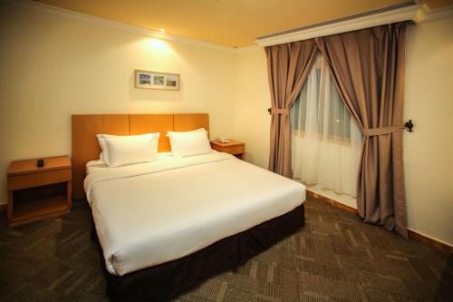 a bedroom with a large bed and a window at Etab Hotels & Suites in Al Khobar