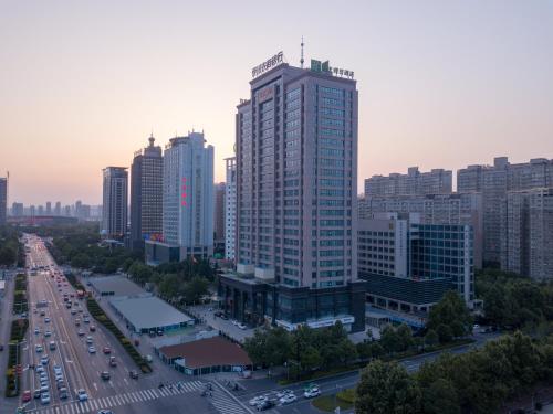 a city skyline with a tall building and traffic at Holiday Inn Express Luoyang City Center by IHG in Luoyang