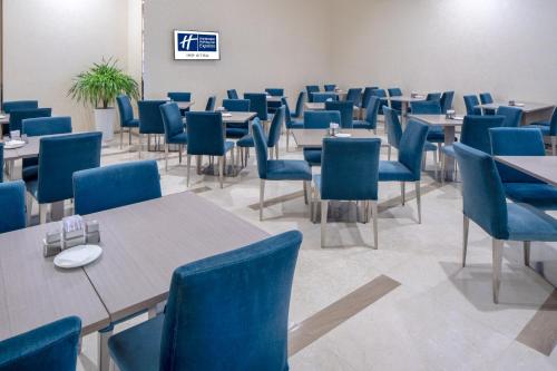 a dining room with tables and blue chairs at Holiday Inn Express Luoyang City Center by IHG in Luoyang