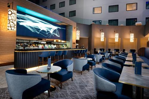 a restaurant with blue chairs and a bar at Holiday Inn Express - London Heathrow T4, an IHG Hotel in Hillingdon