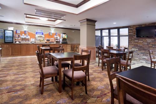 a restaurant with tables and chairs and a bar at Holiday Inn Express Hotel & Suites Lander by IHG in Lander