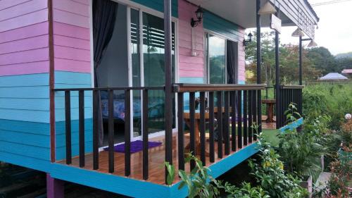 - une terrasse couverte à l'avant d'une maison colorée dans l'établissement D&Dโฮม@เขาค้อ, à Khao Kho