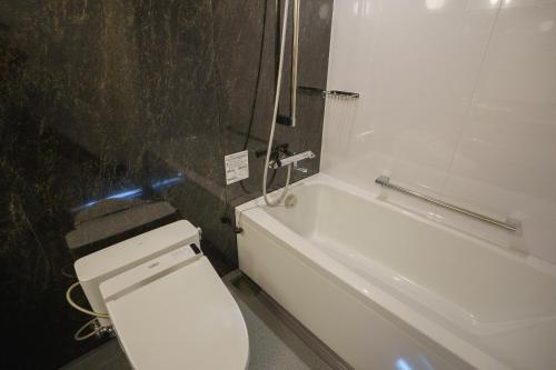 a bathroom with a white toilet and a bath tub at Coto in Miyazu
