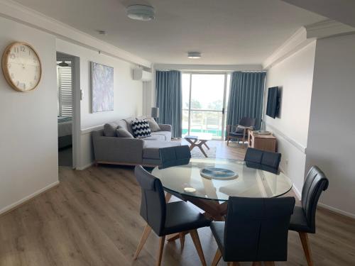 ein Wohnzimmer mit einem Tisch, Stühlen und einem Sofa in der Unterkunft Ocean Plaza Resort in Gold Coast