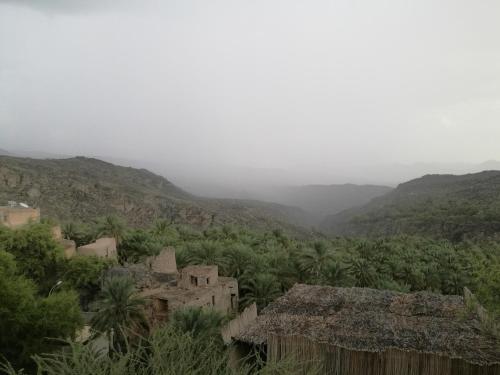 a view of a village with mountains in the background at Basmat almisfah in Al Ḩamrāʼ