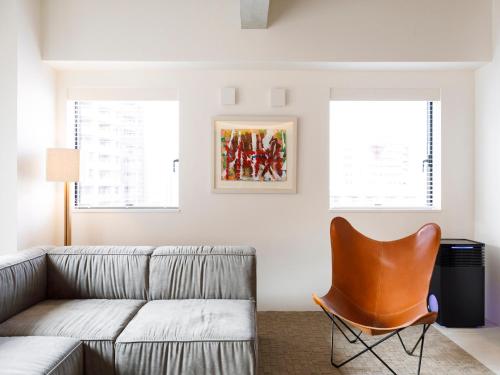 a living room with a couch and a chair at Hotel Mei Fukuoka Tenjin in Fukuoka