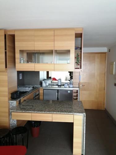 a kitchen with wooden cabinets and a counter top at Departamento Boutique in Concón