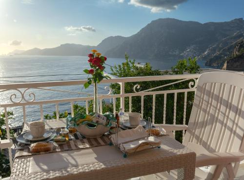 un tavolo con cibo su un balcone con vista sull'oceano di Casa Sea la Vie a Praiano