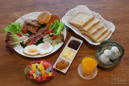 The Bliss Khao Sok Boutique Lodge في خاو سوك: طاولة مليئة بطبق من طعام الإفطار