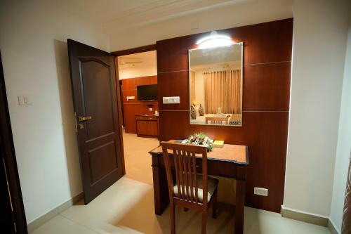 a room with a wooden table and a mirror at Kallelys Park Inn, Chalakudy ,Thrissur in Kizhake Chālakudi