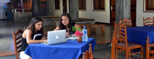 two women sitting at a table with a laptop at Star Beach Guest House in Negombo