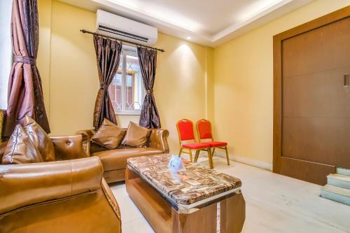 a living room with a couch and a table at FabHotel Luxor - Nr Acropolis Mall in Jādabpur