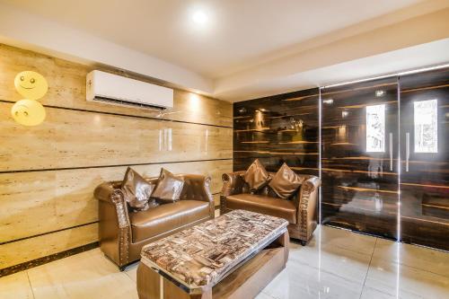 a living room with two leather chairs and a table at FabHotel Luxor - Nr Acropolis Mall in Jādabpur