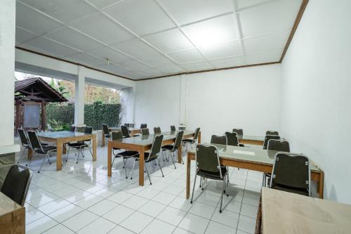 a room with tables and chairs and a large window at Hotel O Omah Duwet in Yogyakarta