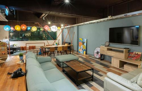 a living room with couches and a flat screen tv at Uno Backpackers Inn in Kaohsiung