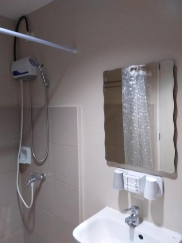 a bathroom with a shower and a sink and a mirror at AJ Sundiva Tower w balcony in Cebu City