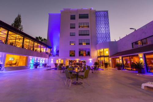 a building with tables and chairs in a courtyard at night at Amman International Hotel in Amman